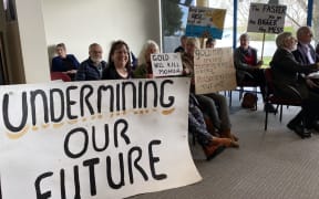 Golden Bay residents carried signs opposing gold mining in the council meeting.