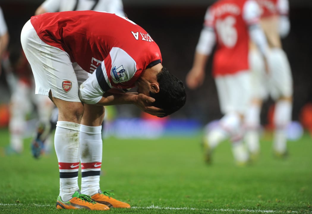 Arsenal's Mikel Arteta holds his head in dejection.