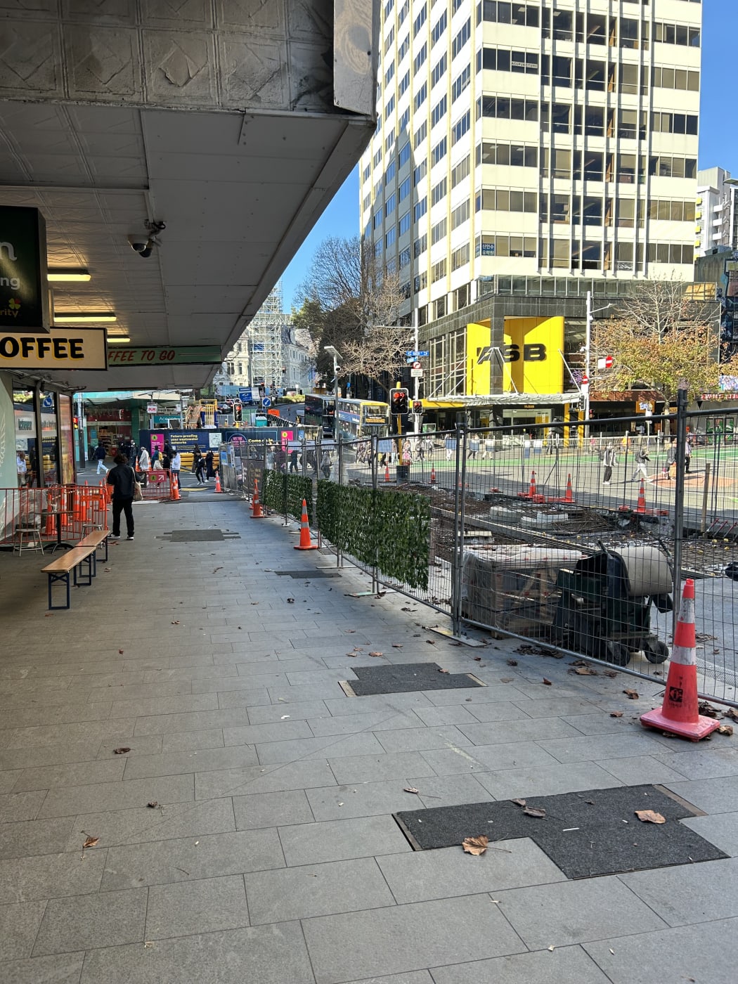 Image shows roadwork in Auckland's CBD. A line of orange road cones extend into the distance.