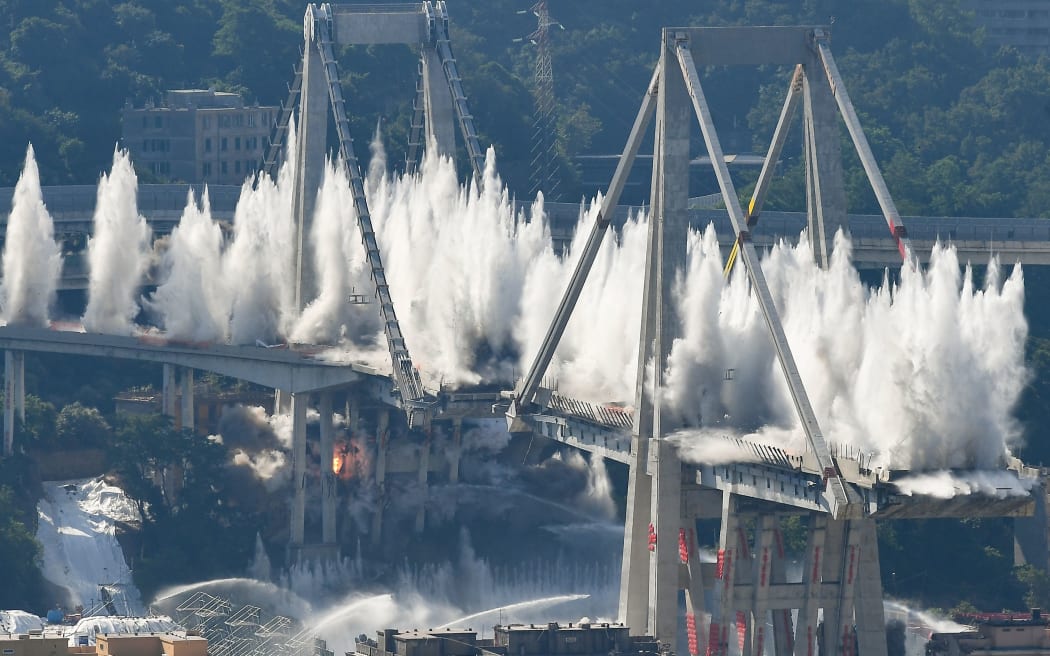 Explosive charges blow up the eastern pylons of Genoa's Morandi motorway bridge on June 28, 2019 in Genoa. -