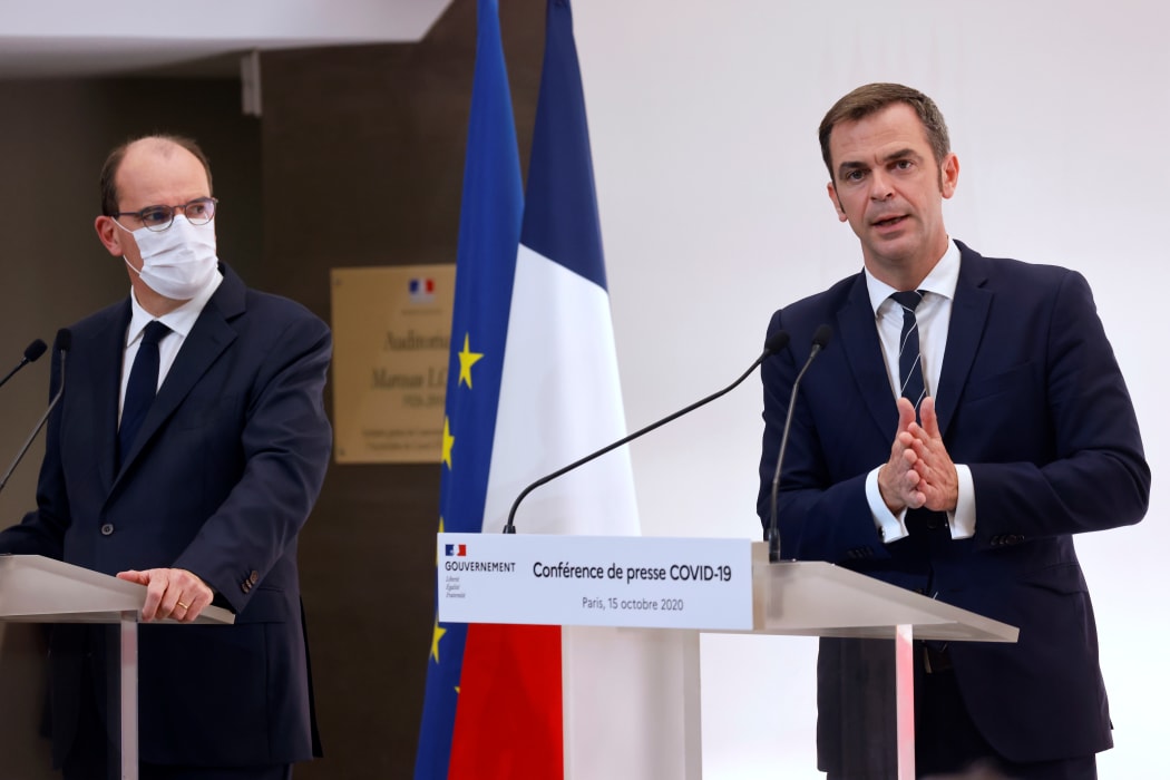 French Health Minister Olivier Veran (right) speaks flanked by French Prime Minister Jean Castex  during a press conference on 15 October to present the details of new restrictions aimed at curbing the spread of the Covid-19 pandemic.