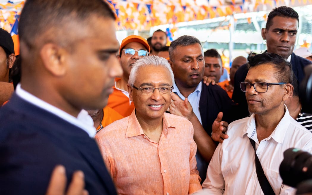 Prime Minister of Mauritius and candidate for the Militant Socialist Movement (MSM) Pravind Jugnauth (C) is surrounded by supporters during a campaign rally in Mahebourg on October 20, 2024, ahead of the 2024 Mauritian general election. (Photo by Laura Morosoli / AFP)