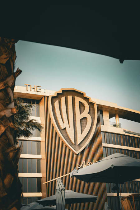 A buliding displays the Warner Bros 'WB' logo in shades of brown.