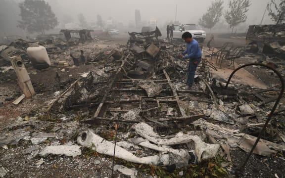 A man looks for items in the remains of his mobile home after a wildfire swept through the R.V. park destroying multiple homes in Estacada, Oregon