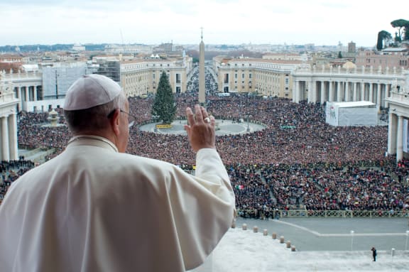Pope Francis gives his blessing from a balcony at the Vatican.