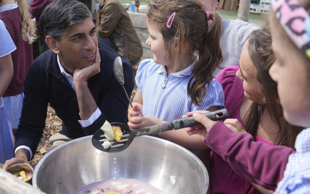 FILE - Britain's Prime Minister Rishi Sunak reacts as he speaks to school children during an election campaign visit to the Holy Trinity Rosehill CofE Primary school in Teeside, northeast England, Friday, June 28, 2024. (AP Photo/Kin Cheung, Pool, File)
