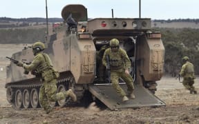 Australian Army soldiers run from an armoured personnel carrier during Excercise Chong Ju, a live fire demonstration showcasing the army's joint combined arms capabilities at the Puckapunyal Military Base north of Melbourne on May 9, 2019.