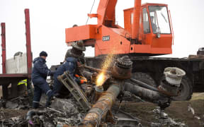 Dutch experts supervise a crew from the self-proclaimed Donetsk People's Republic as they remove parts of Malaysia Airlines Flight MH17 on 16 November in Ukraine.