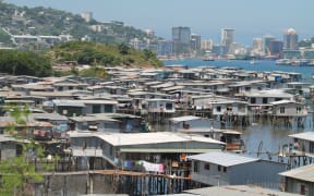 Hanuabada, the original village of Papua New Guinea's capital city Port Moresby inhabited by the Motuan people; with the CBD in the background.