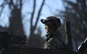 A Ukrainian soldier in an armoured vehicle waits on the west side of the Ukrainian capital of Kyiv on February 26, 2022.