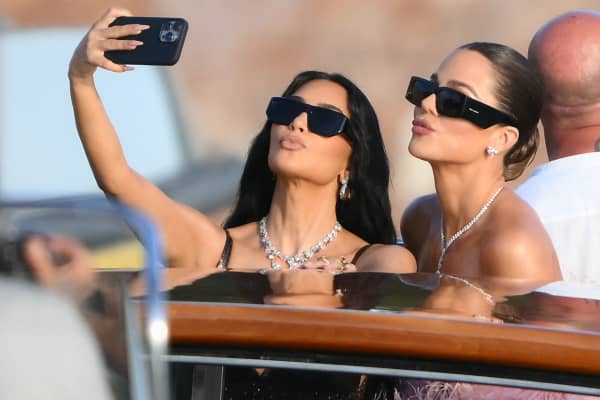TOPSHOT - US reality TV personality Kim Kardashian (L) and US socialite Khloe Kardashian snap a selfie as they arrive at San Giorgio Maggiore on the wedding day of Amazon founder Jeff Bezos with Lauren Sanchez, in Venice on June 27, 2025.  (Photo by Marco BERTORELLO / AFP)