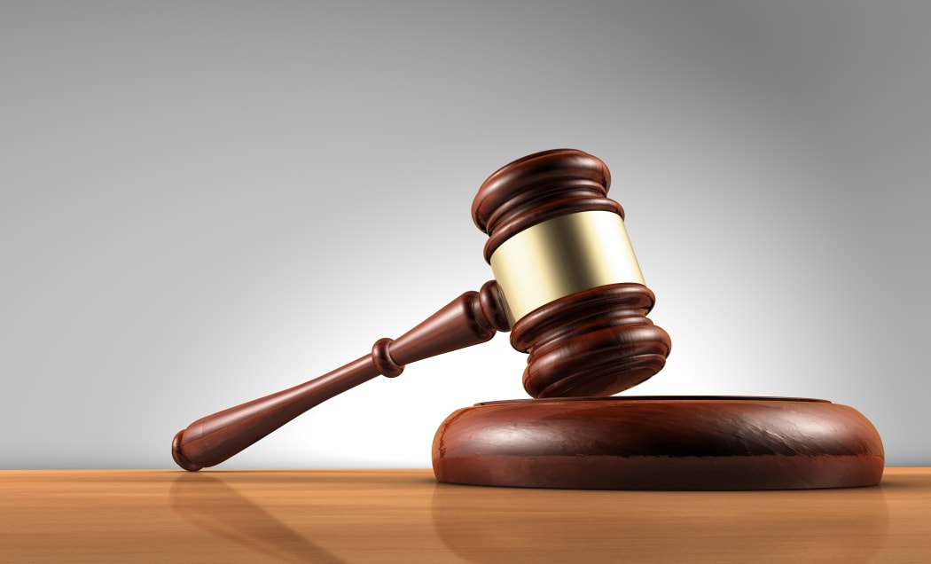 Judge, law, lawyer and Justice concept with a 3d render of a gavel on a wooden desktop with grey background.