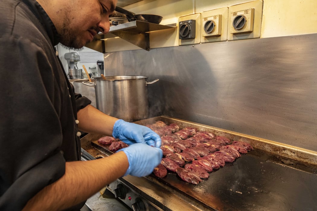 Assistant chef Alex Mahral cooks pūkeko on the hotplate.