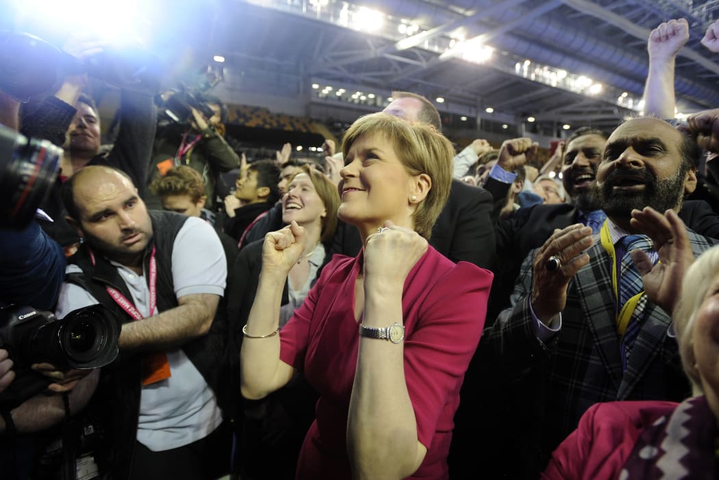 SNP leader Nicola Sturgeon (C) celebrates as election results are announced - with the party taking 56 out of 59 seats in Scotland.