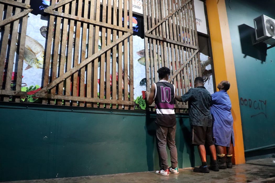 People secure their shop with planks ahead of the arrival of Cyclone Yasa in Fiji's capital city of Suva on December 16, 2020.