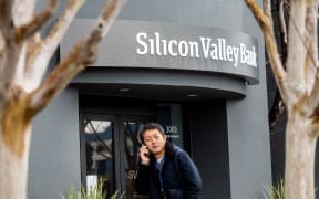 A pedestrian speaks on a mobile telephone as he walks past Silicon Valley Bank’s headquarters in Santa Clara, California on March 10, 2023. - US authorities swooped in and seized the assets of SVB, a key lender to US startups since the 1980s, after a run on deposits made it no longer tenable for the medium-sized bank to stay afloat on its own. (Photo by NOAH BERGER / AFP)