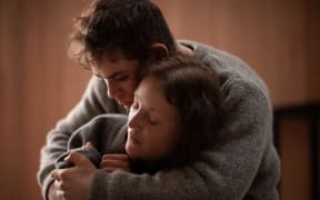 A shot from the film Went Up the Hill of actor Dacre Montgomery holding actress Vicky Krieps.