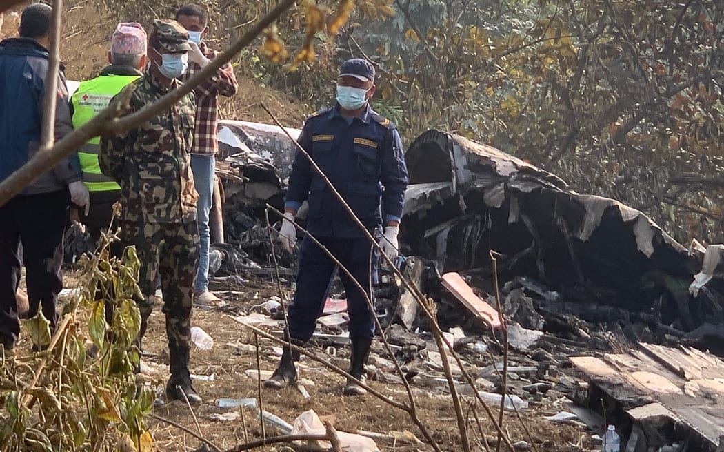 Rescuers gather at the site of a plane crash in Pokhara on January 15, 2023. - At least 67 people were confirmed dead on January 15 when a plane with 72 on board crashed in Nepal, police said, in the Himalayan country's deadliest aviation disaster in three decades. (Photo by Prakash MATHEMA / AFP)