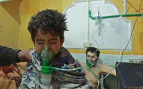 Syrian children and adults receive treatment for a suspected chemical attack that killed a child and 13 adults at a makeshift clinic on the rebel-held village of al-Shifuniyah in the Eastern Ghouta region on the outskirts of Damascus on 25 February 25, 2018.