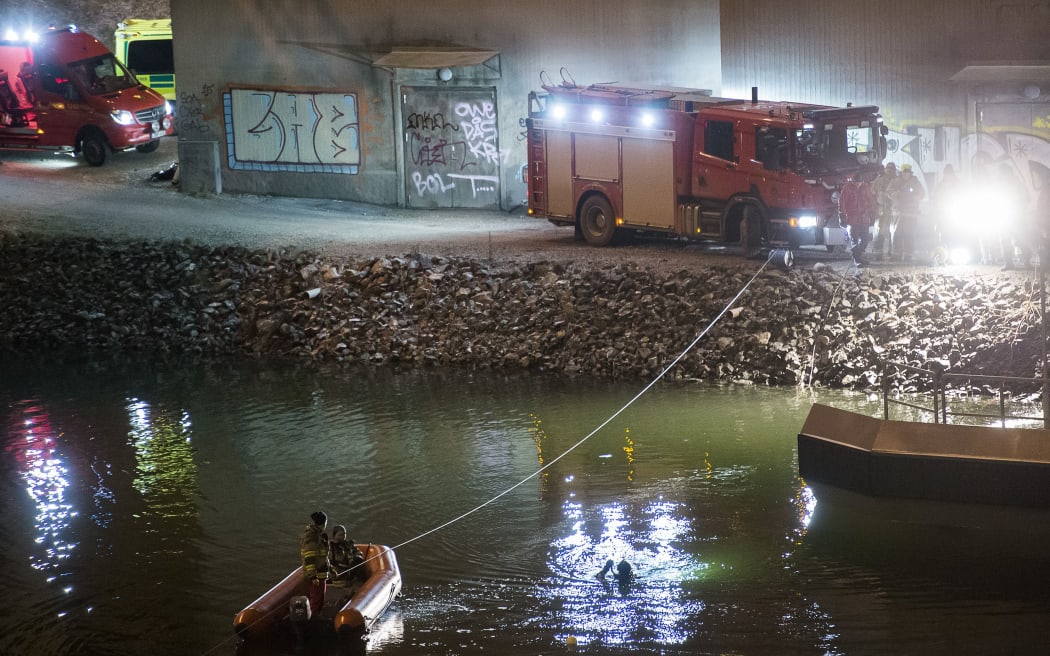 Divers and rescue service personnel search for the victims of the deadly car crash in Sodertalje, Sweden.
