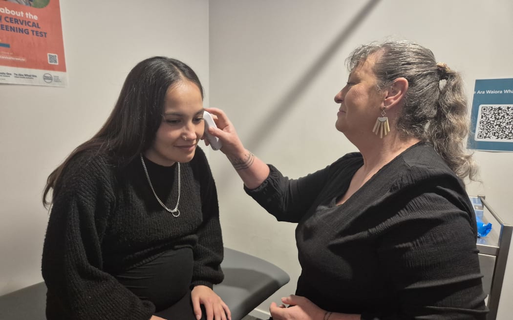 Macy Te Whaiti having her temperature checked by registered nurse Tina Carrell