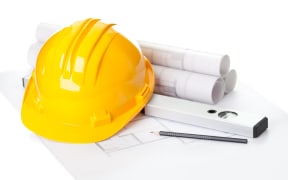 Building plans and hard hat on a table.