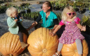 Korra Blackwell, mum Nelly and Hazel Blackwell with last year's winning giant pumpkins.