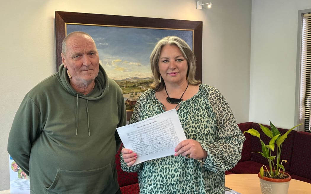 Kerry Low presents a petition to Central Hawke's Bay mayor Alex Walker calling for the closure of a new vape shop in Otāne.