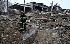 A rescuer walks amid rubbles of a destroyed building following Russian strikes in Kharkiv, eastern Ukraine on 16 December, 2022.