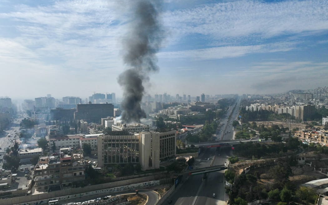 This aerial photo shows smoke billowing from a building in Damascus on 8 December 2024, after rebels took the city.