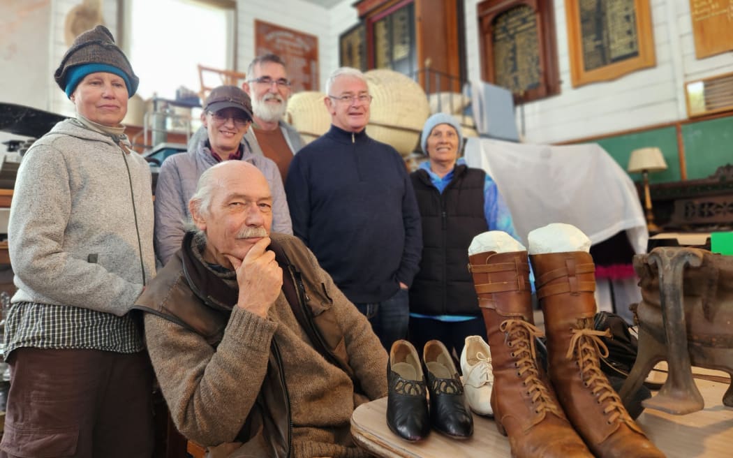 Volunteers dressed in warm clothing, posing for the camera in the museum's chilly workroom