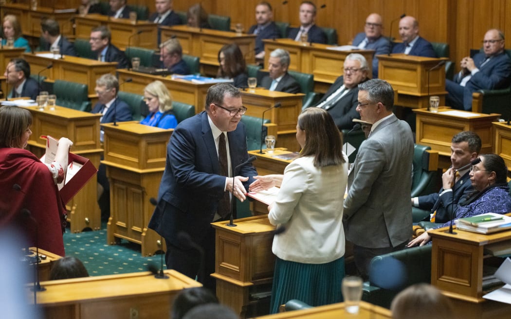 Minister of Finance Grant Robertson hands a copy of the Budget Speech to Green Co-Leader Marama Davidson prior to the delivery of the speech.