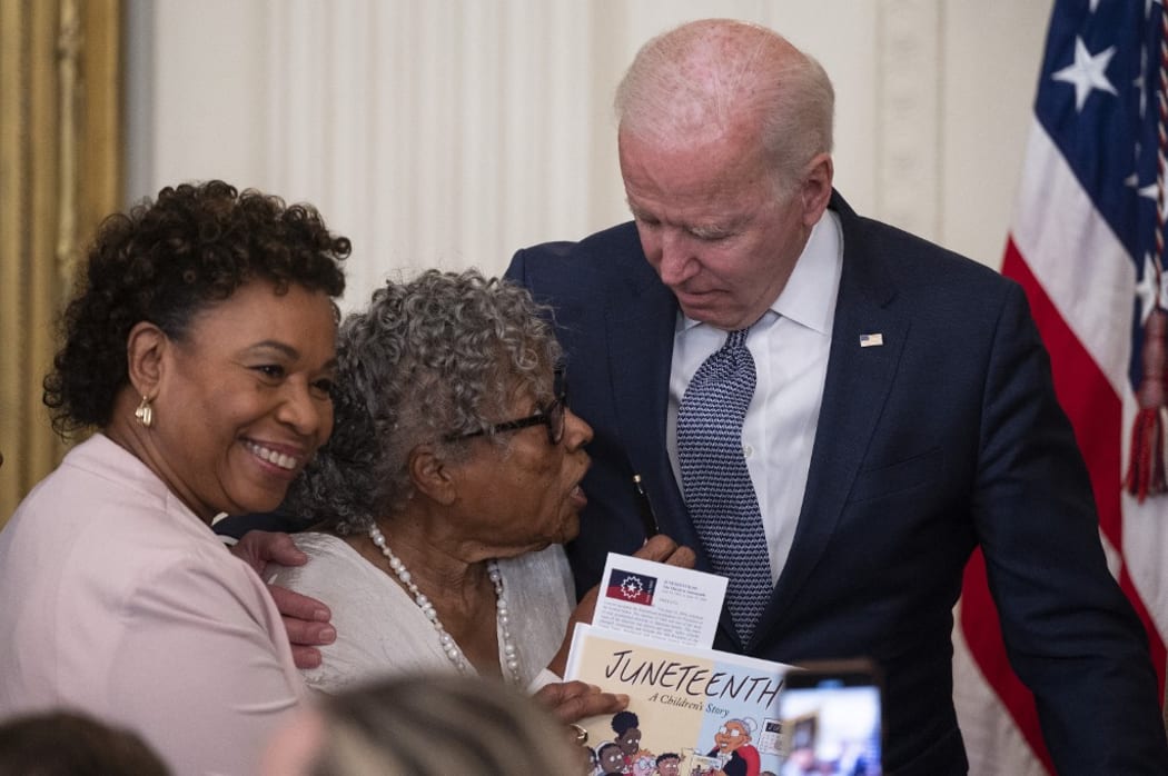 Opal Lee (2nd L), the activist known as the grandmother of Juneteenth, speaks with US President Joe Biden after he signed  the Juneteenth National Independence Day Act, in the East Room of the White House, June 17, 2021, in Washington.