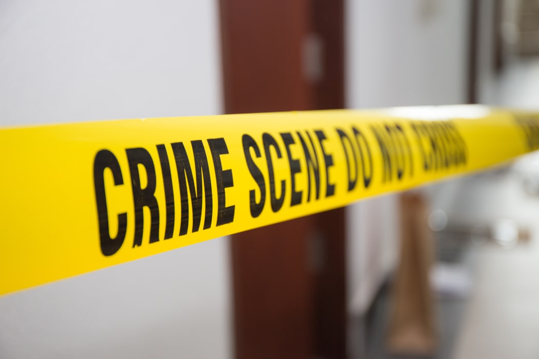 crime scene tape in front of room door with blurred background