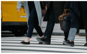 workers crossing road carrying briefcases
