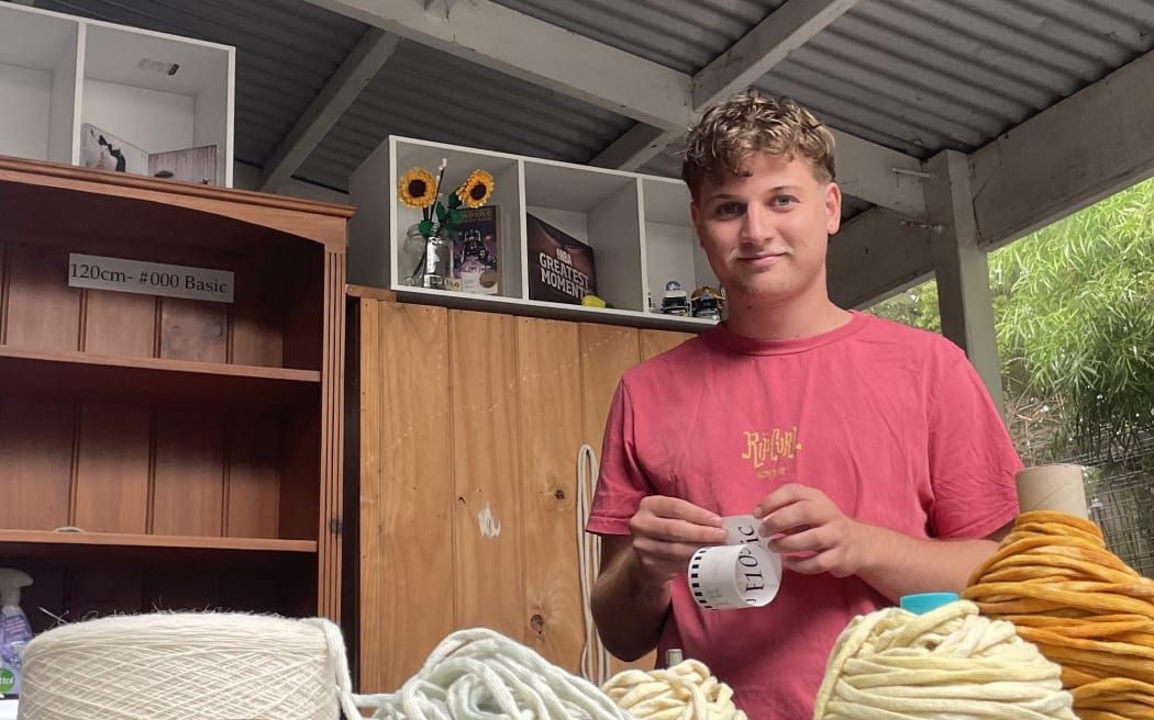 Jacob Smith in his studio with rolls of shoelace material in front of him