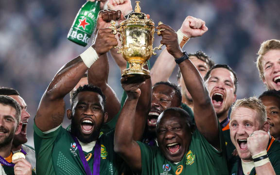 South Africa's Siya Kolisi lifts the Webb Ellis Trophy with Cyril Ramaphosa.