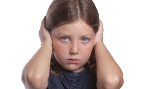 little girl covers ears