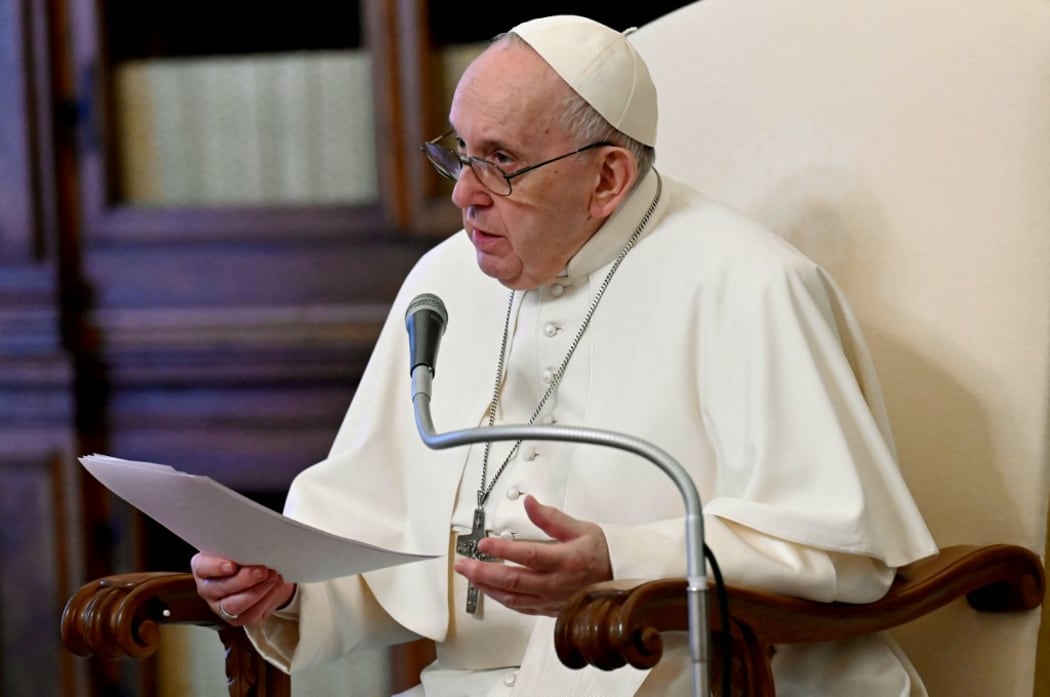 This handout photo taken and released on April 28, 2021 by the Vatican Media shows Pope Francis, delivering his message during a live streamed weekly private audience in the library of the apostolic palace, in The Vatican.