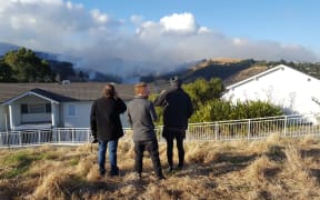 Henry Reese, centre, watches his family home burn to the ground