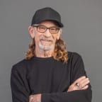 Trevor Reekie smiling wearing a black cap