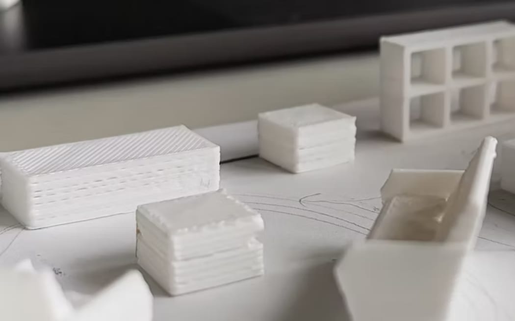 A model layout of a lounge room using small white tokens on a piece of paper.