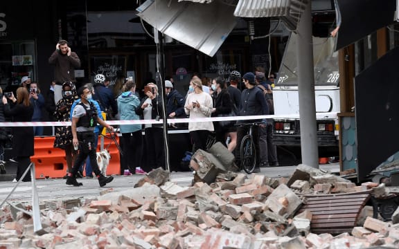 Residents gather near a damaged building in the popular shopping Chapel Street in Melbourne on September 22, 2021, after a 5.8-magnitude earthquake.
