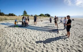 Caleb Harcus and his son, Ethan, trialled a new Mobi-Mat at Tāhunanui on Monday, a device that allows wheelchair users and those with strollers and walkers, who struggle to get over soft sand, to get closer to the water.