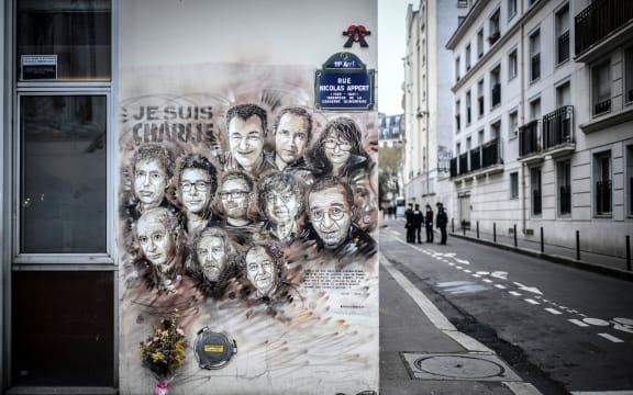 File photo taken on January 7, 2019 shows police officers next to a painting by French street artist and painter Christian Guemy, known as C215, in tribute to members of Charlie Hebdo newspaper who were killed in January 2015.