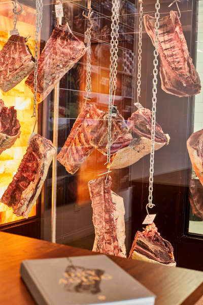 Premium cuts hang in a dry aging cabinet at the Matangi Boutique Butchery and Showroom in Hastings.