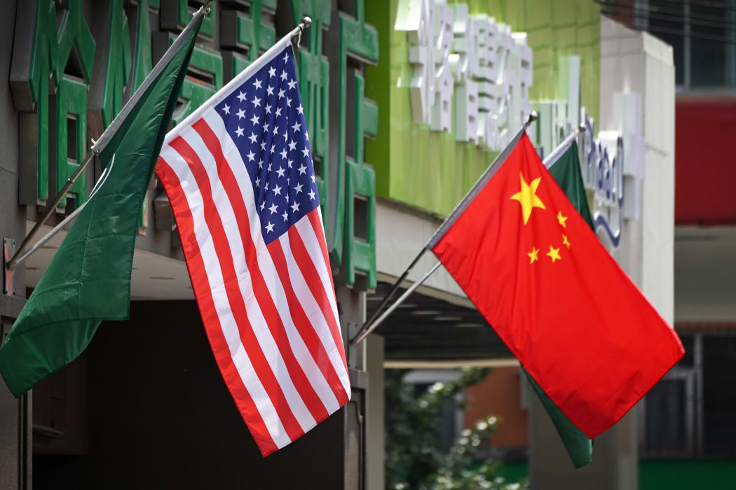 The US (L) and Chinese flags are displayed outside a hotel in Beijing on May 14, 2019. - Beijing's latest retaliation against US tariff hikes -- an increase on $60 billion of US imports from June 1 -- could leave China running low on ammunition in the trade war. (Photo by Greg Baker / AFP)