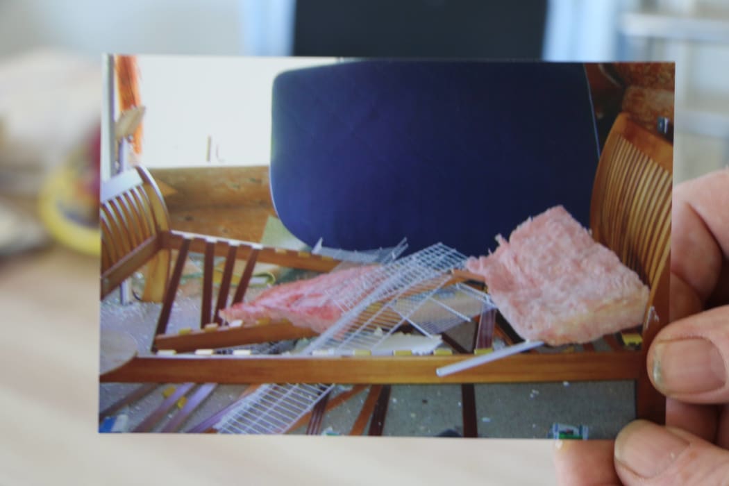 Don McIntosh with a photo of his bed that was split in half in the earthquake.