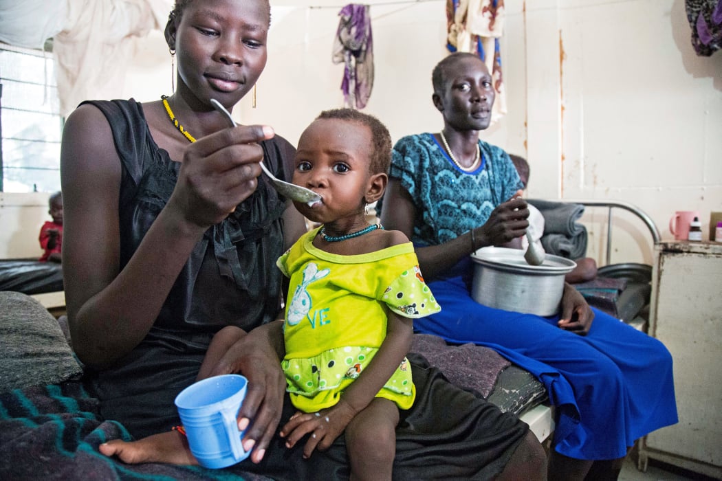 A mother gives food to her child with malnutrition in a clinic in Old Fangak, Jonglei state