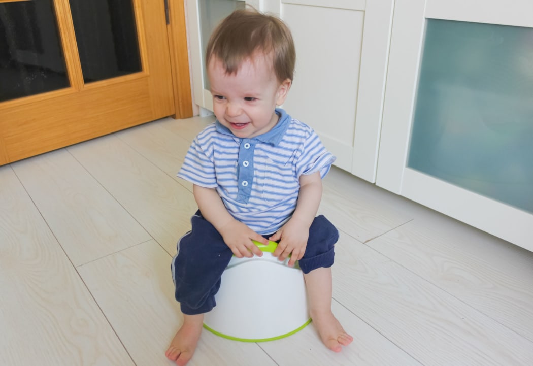 A photo of a small boy learning to use the potty